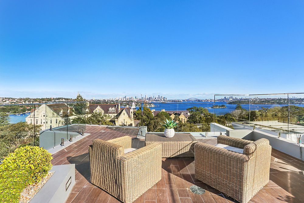 A rooftop deck with wicker furniture and a view of the city.