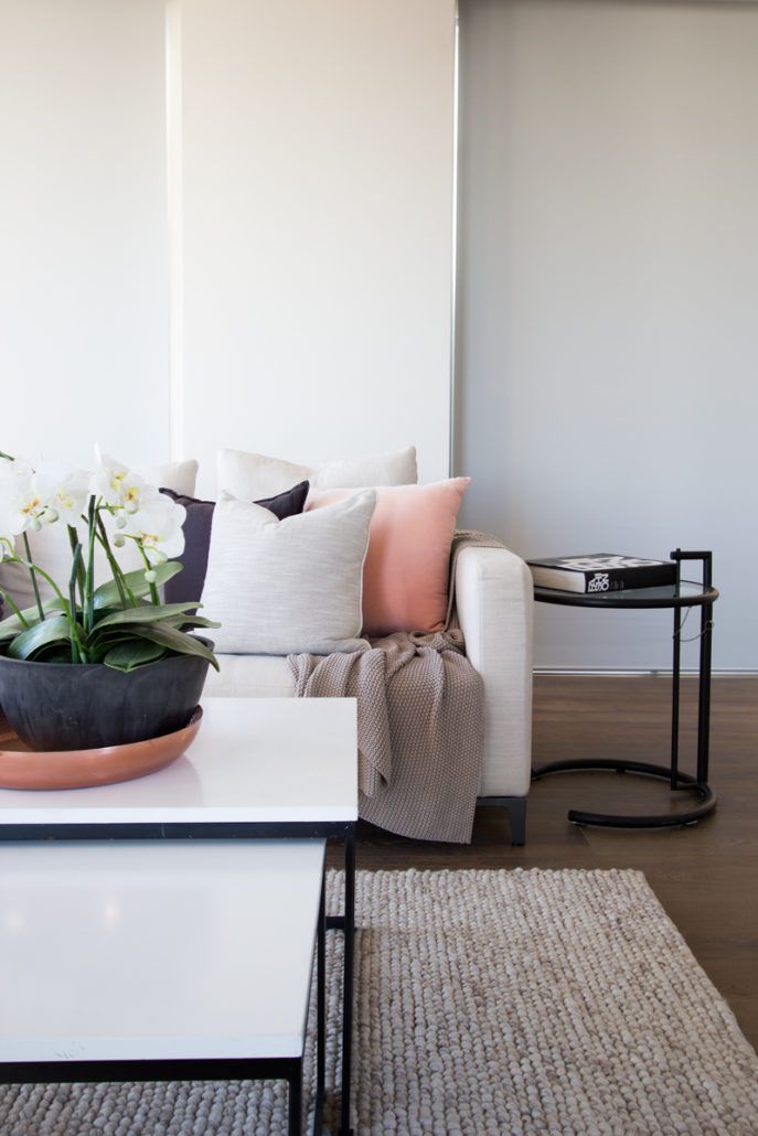 A living room with a white couch and a white coffee table