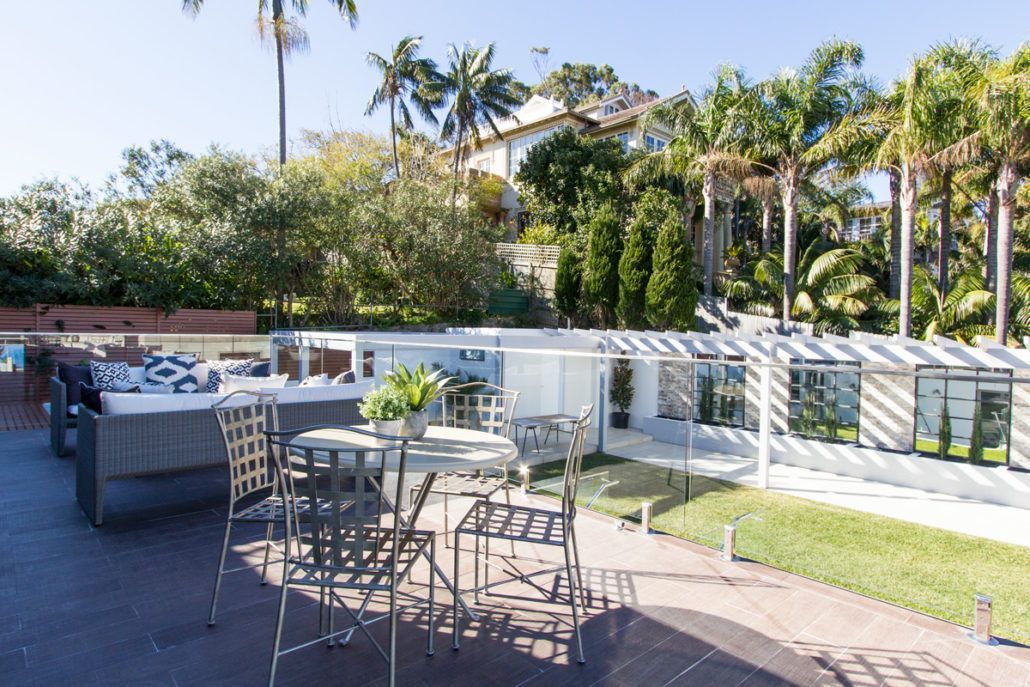 A patio with a table and chairs and a hot tub.