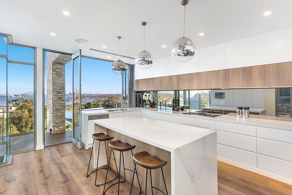 A modern kitchen with a large island and stools.