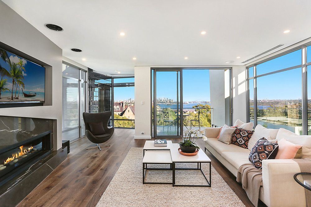 A living room with a couch , coffee table , fireplace and television.