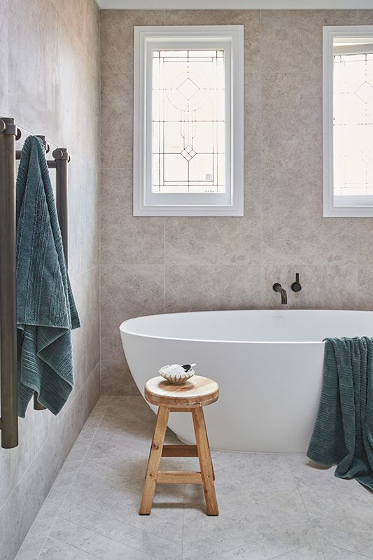 A bathroom with a bathtub and a wooden stool.