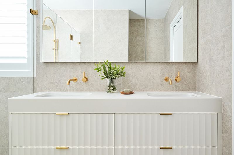 A bathroom with two sinks and a large mirror.