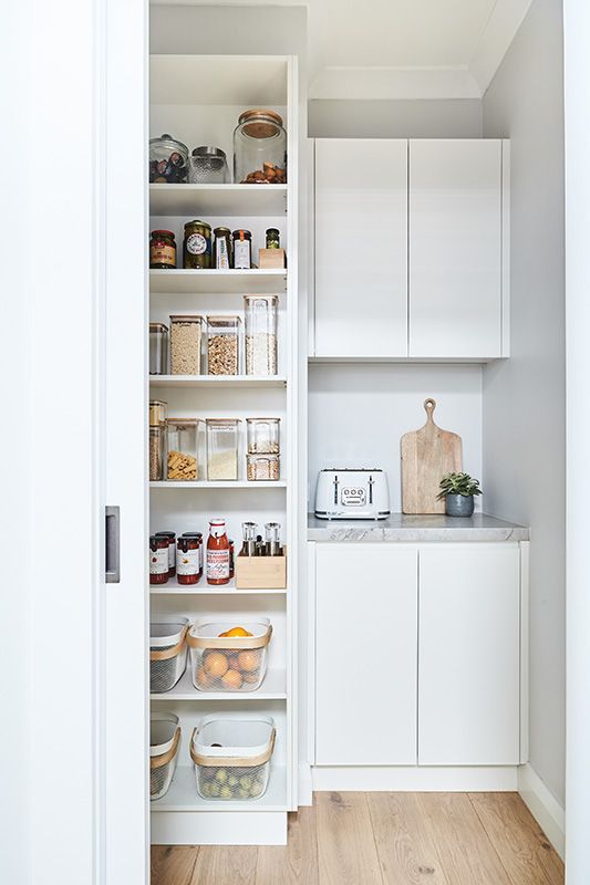 A pantry with lots of shelves and a toaster oven.