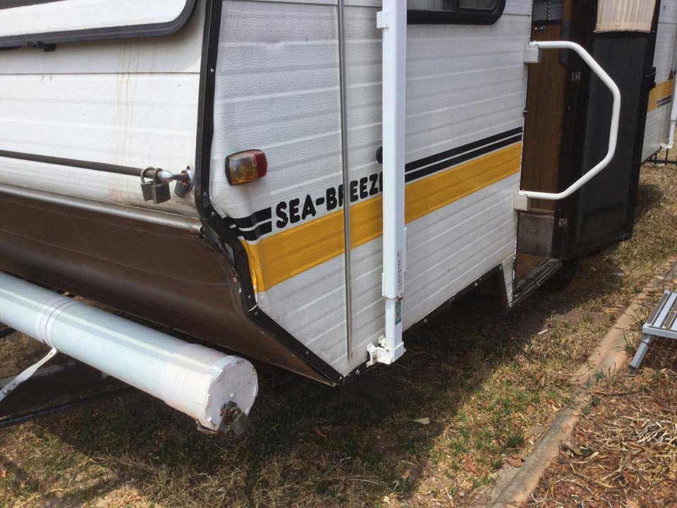 Rear view of a Sea-Breeze camper with yellow and brown accents, and a step up to the door — Darwin Caravan & RV Centre In Berrimah, NT