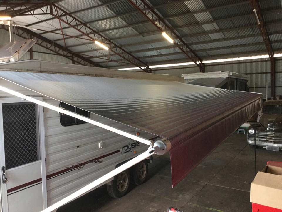 A RV  is Parked in a Garage With an Awning Attached to It — Darwin Caravan & RV Centre In Berrimah, NT
