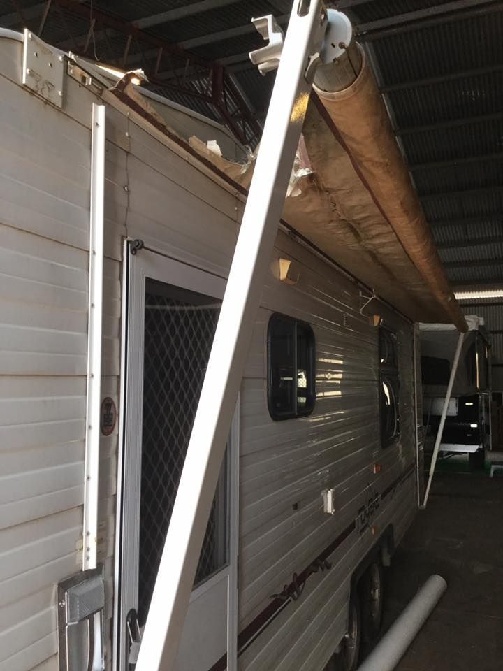 Side view of a caravan with an extended awning. The awning is beige and the caravan is white with a red stripe — Darwin Caravan & RV Centre In Berrimah, NT