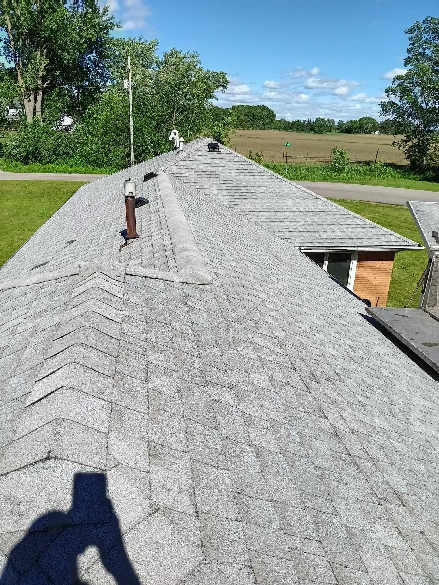 Completed asphalt shingle roof with attic ventilation vents on a Grant, MI home Completed asphalt shingle roof with attic ventilation vents on a Grant, MI home