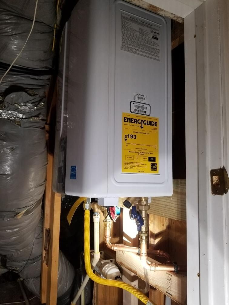 Residential utility panel with yellow gas pipes in a narrow closet, beside insulated ductwork.