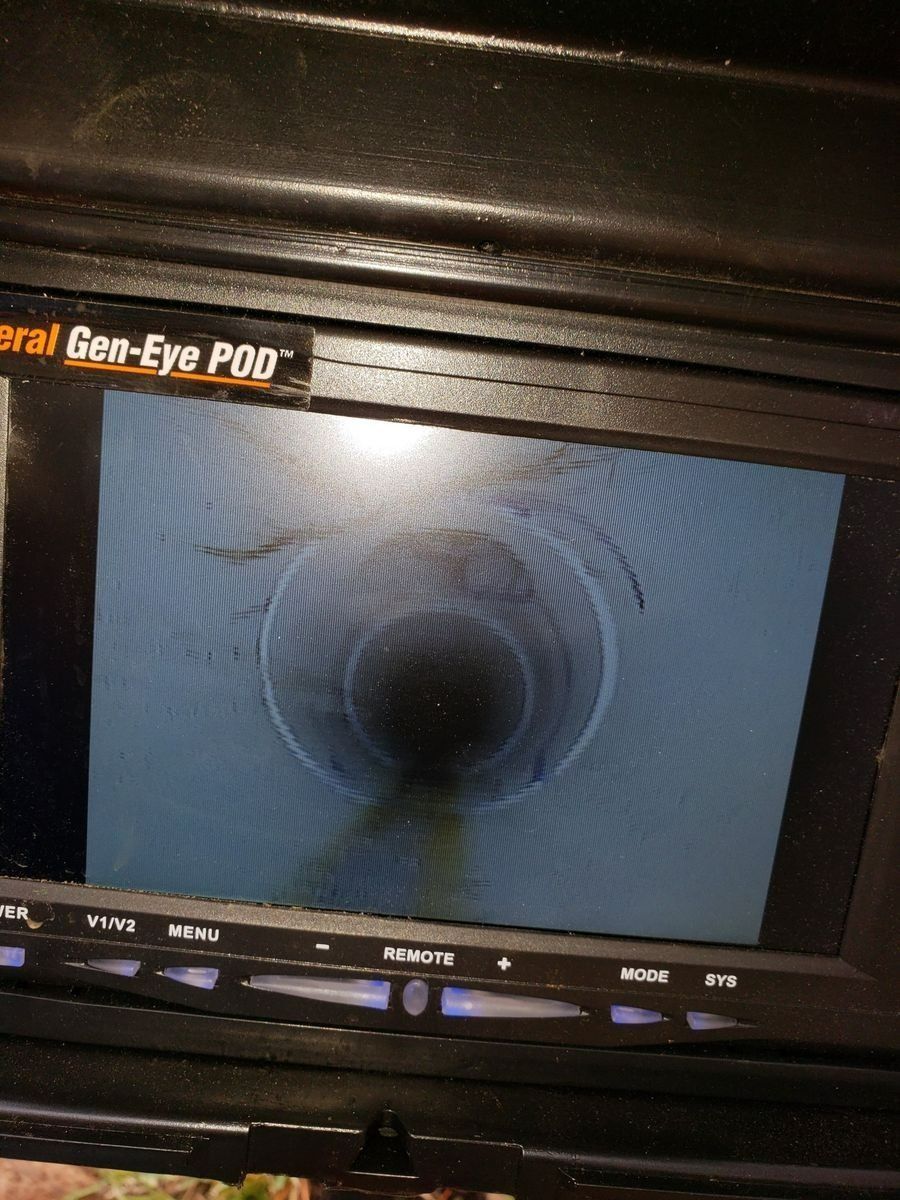 Screen displaying a circular pipe interior with dark center and light blue edges, like a sewer inspection view
