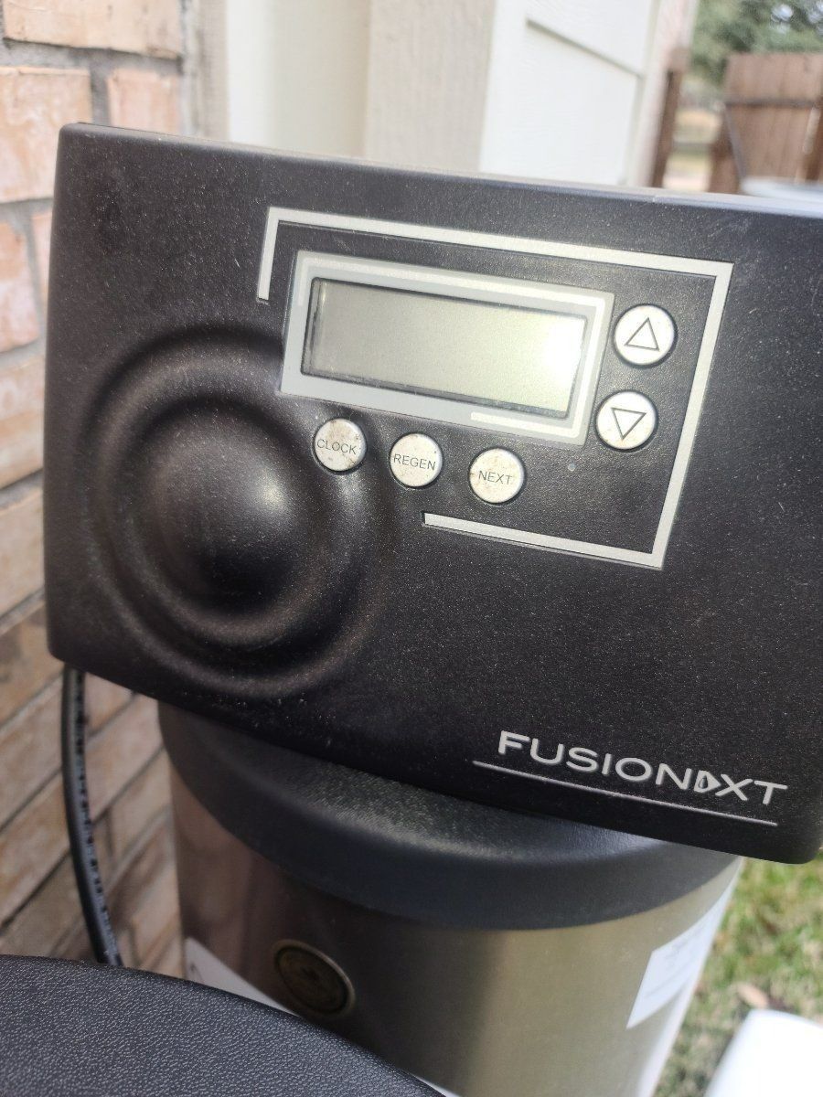 Close-up of a black Fusion NXT device control panel with display, buttons, and a large knob
