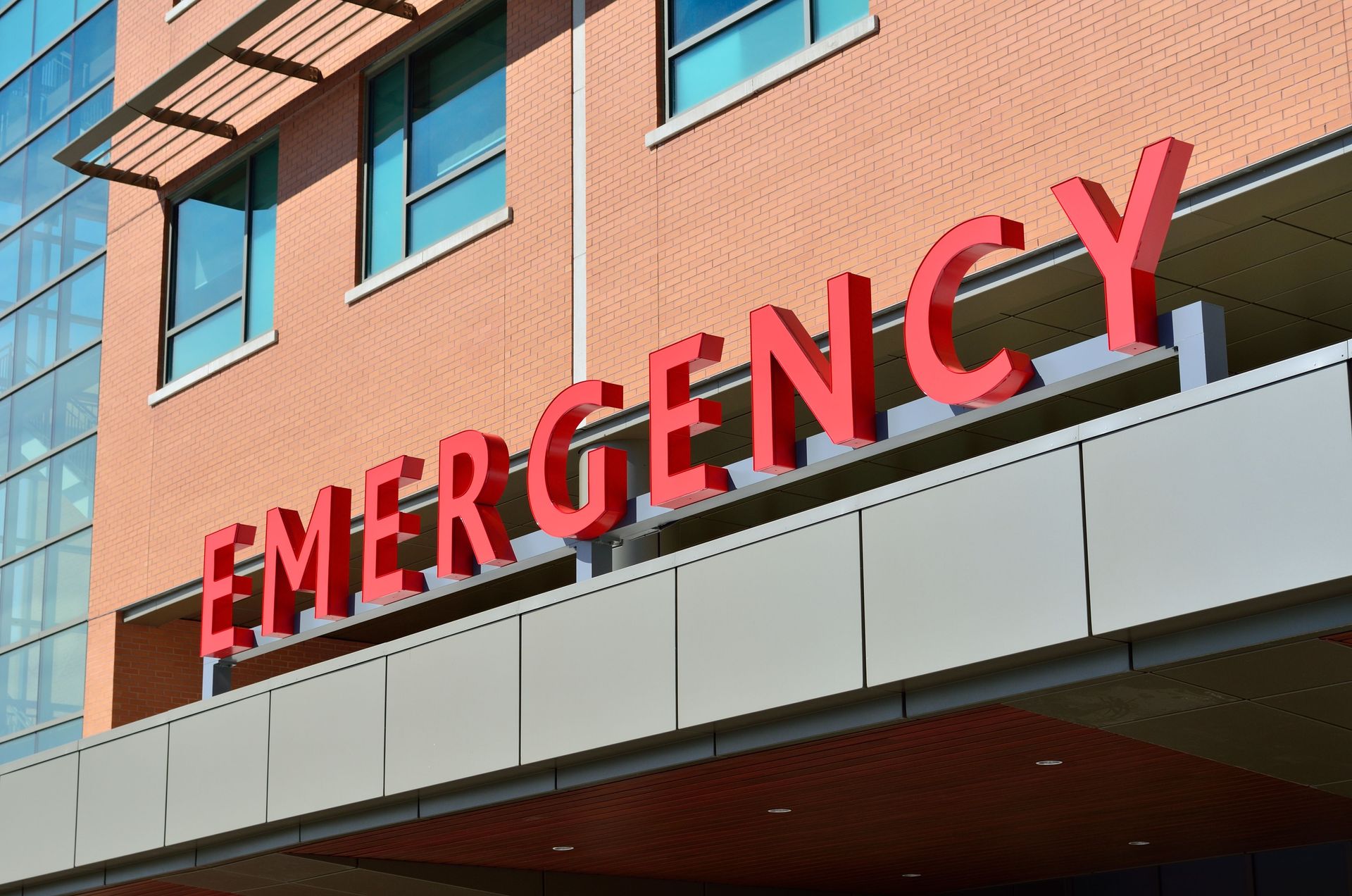 Red “EMERGENCY” sign on a hospital building exterior