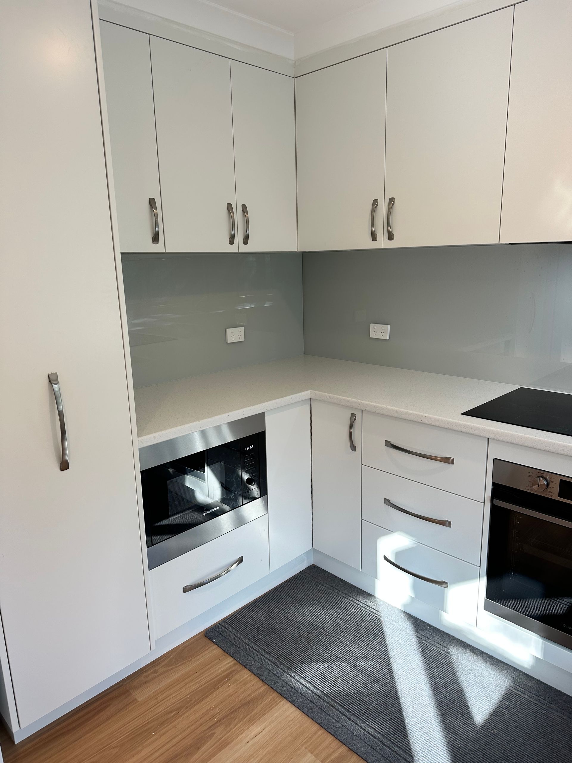 A kitchen with white cabinets and stainless steel appliances