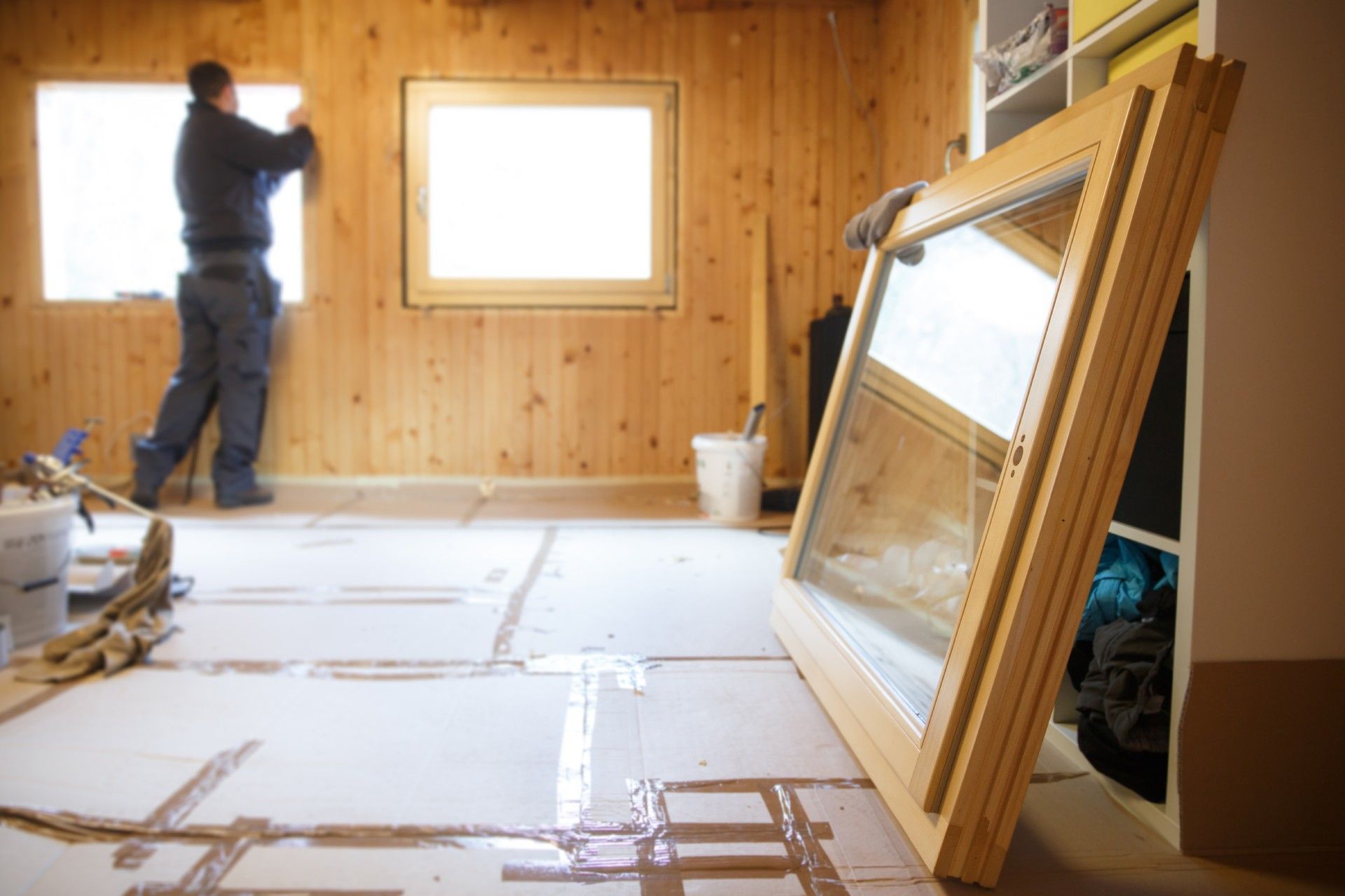 Worker replacing old windows with new windows.