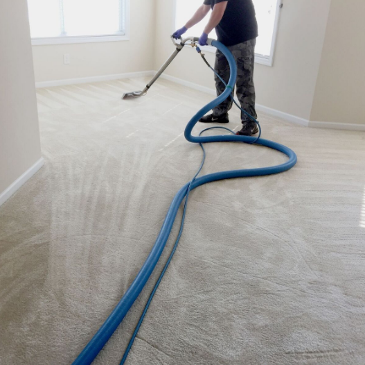 A man is using a vacuum cleaner to clean a carpet
