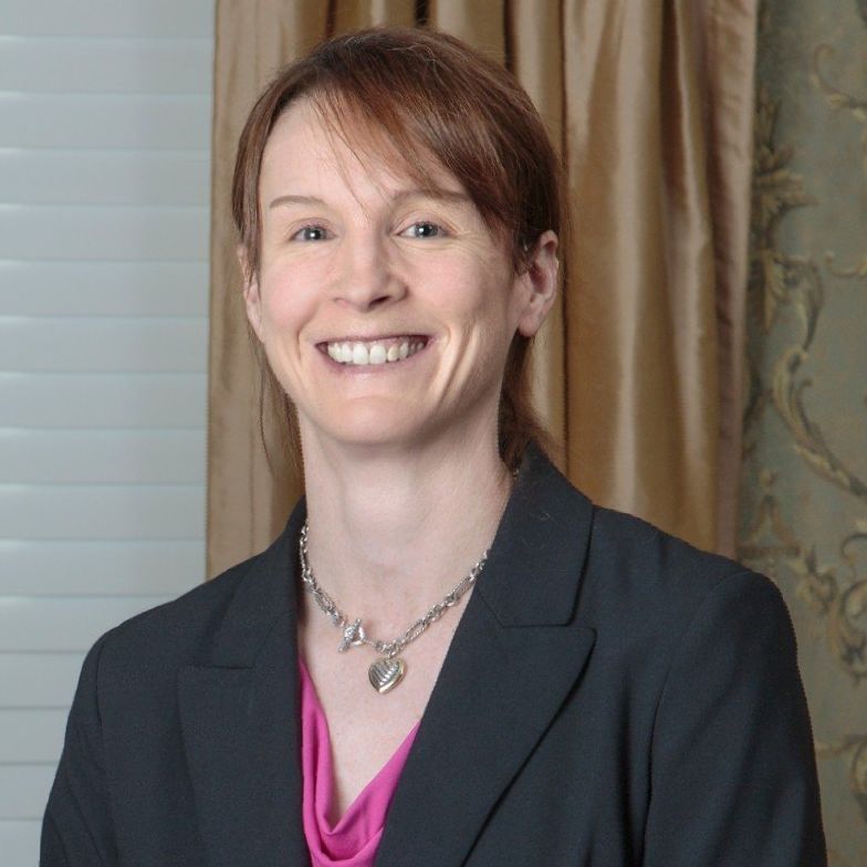 Law Firm Richmond VA: A woman wearing a necklace and a jacket smiles for the camera