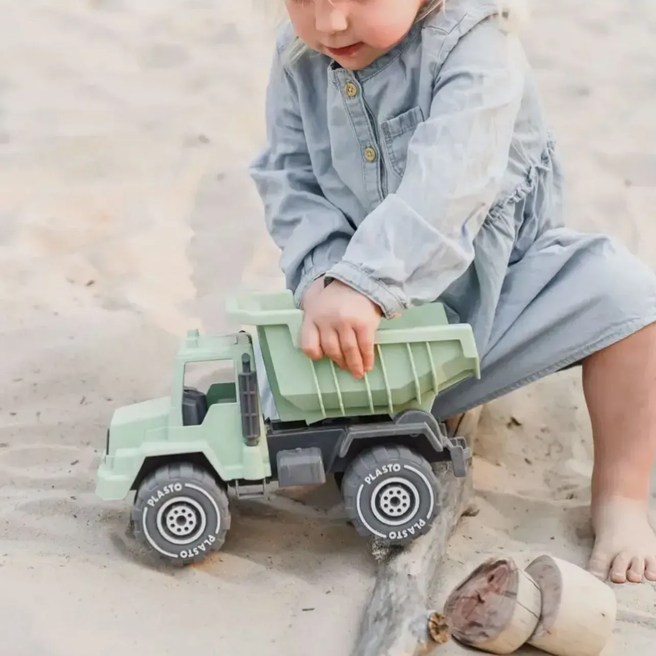 Girl Playing With a Green Toy Dump Truck on Sand — Decadence Gifts & Homewares in Springsure, QLD
