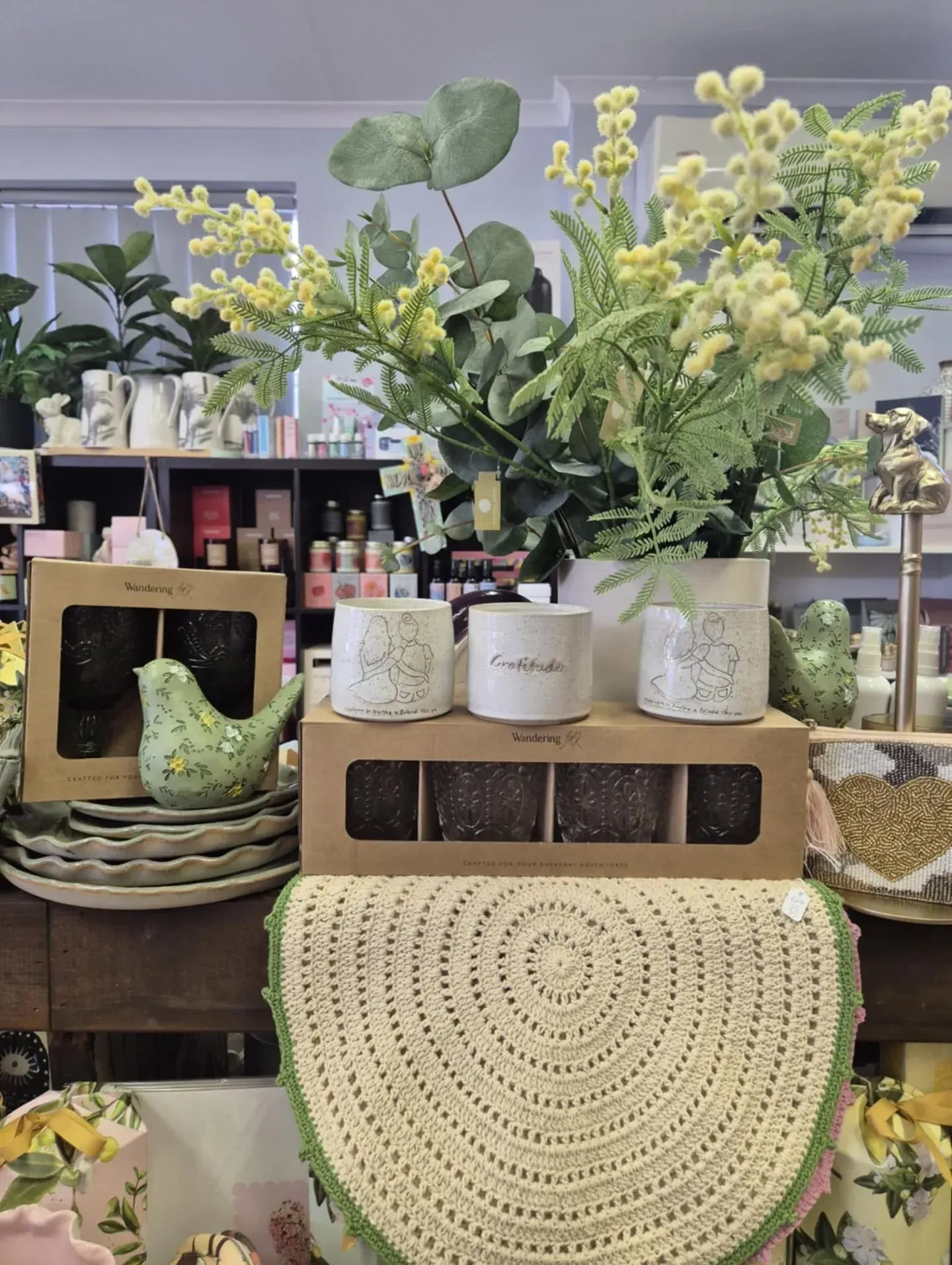 Shop Display With Yellow Flowers, Bird Figurine, and Decorative Candles — Decadence Gifts & Homewares in Springsure, QLD