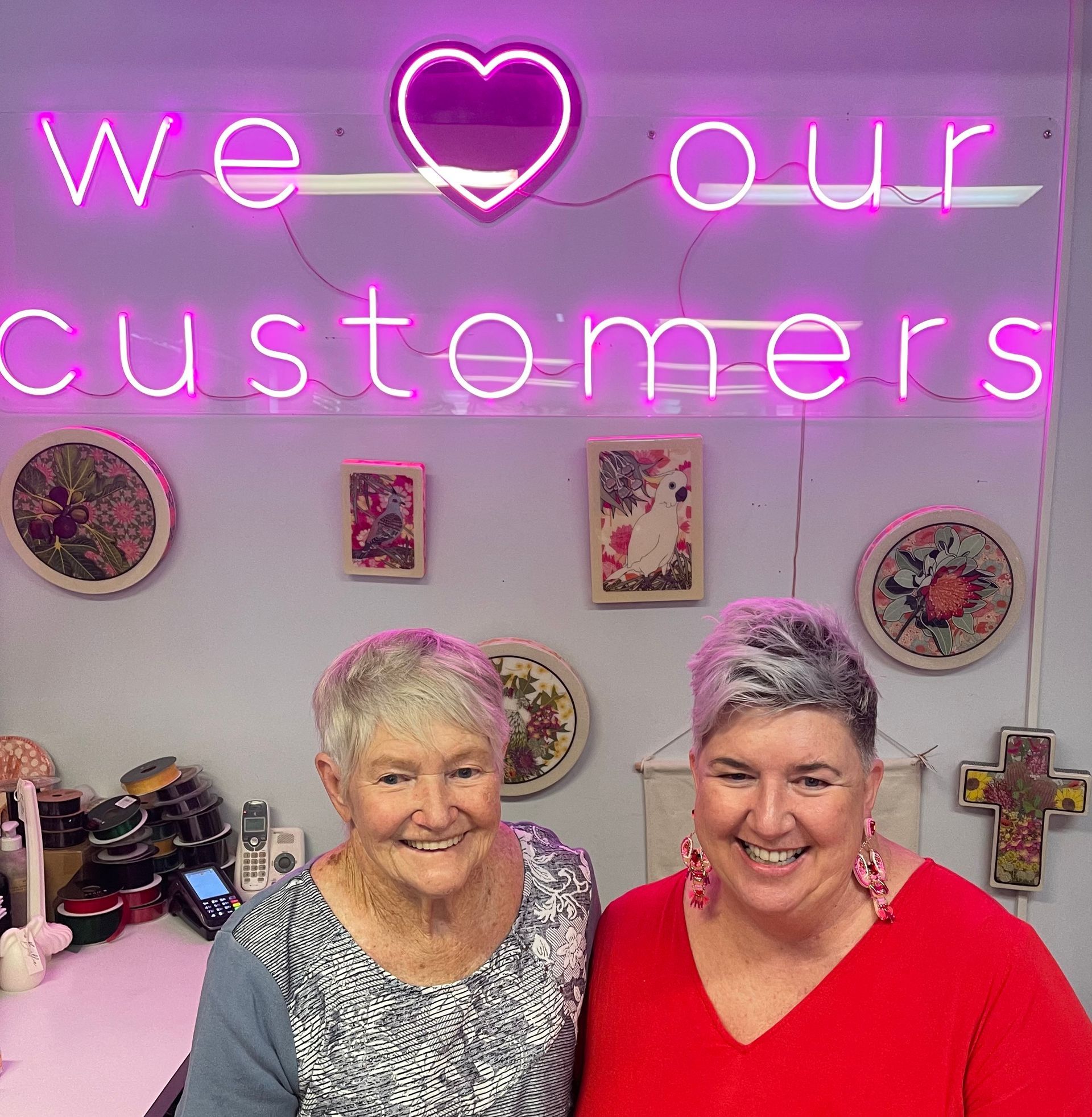 Two Women Smiling Behind a Counter — Decadence Gifts & Homewares in Springsure, QLD