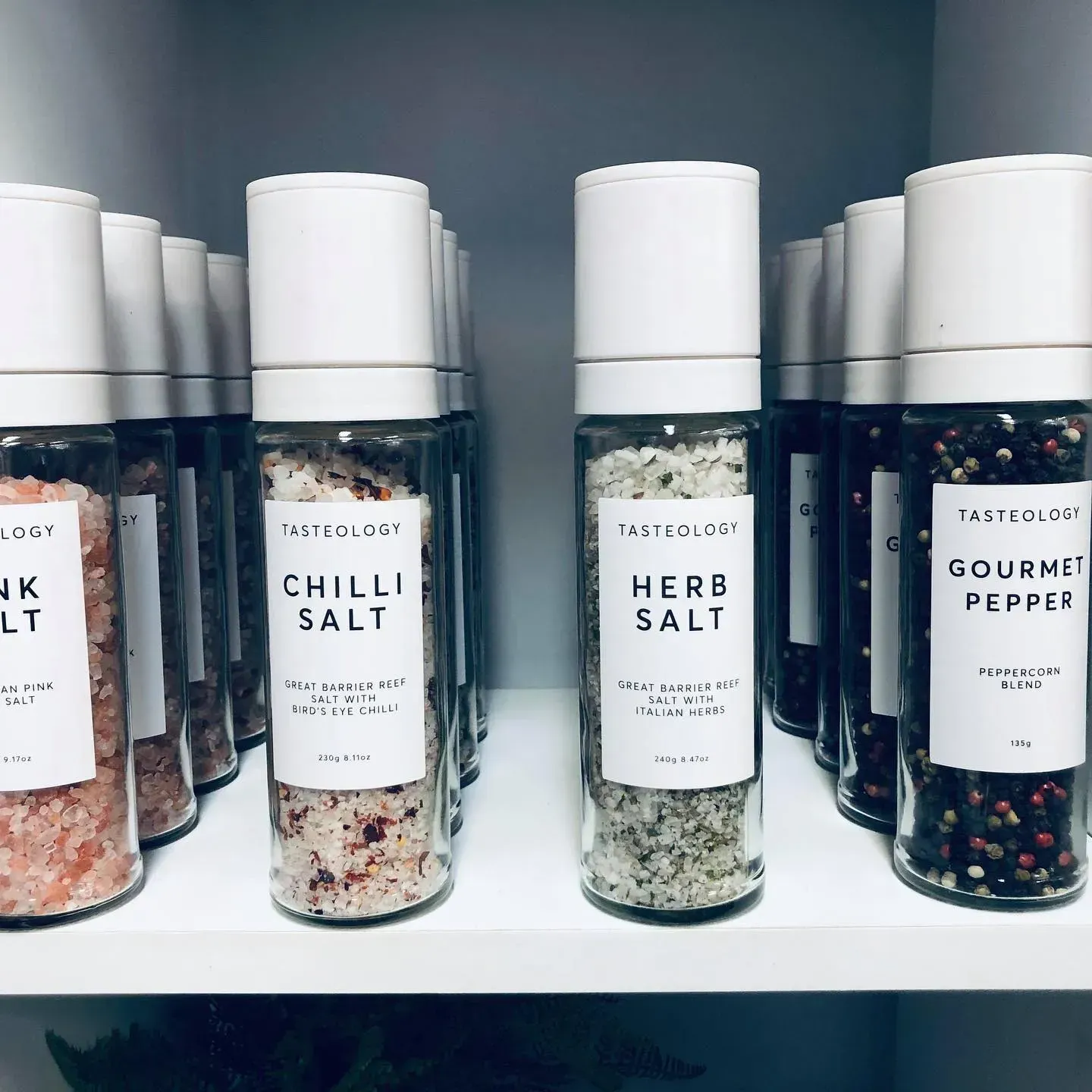 Shelf of Glass Spice Grinders Labeled With Salt and Pepper Varieties — Decadence Gifts & Homewares in Emerald, QLD