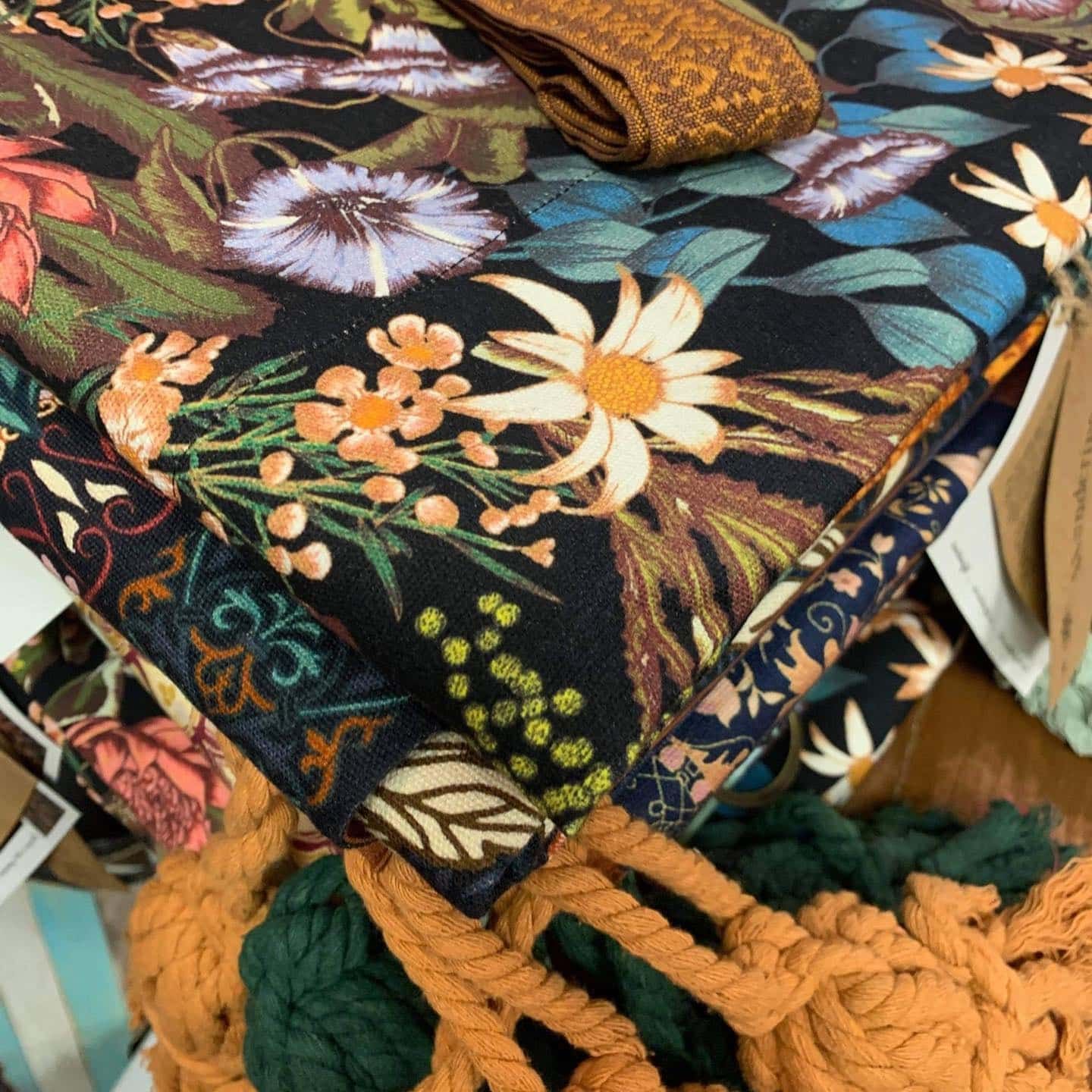 Stack of floral fabric with gold and green accents, and a tassel — Decadence Gifts & Homewares in Springsure, QLD