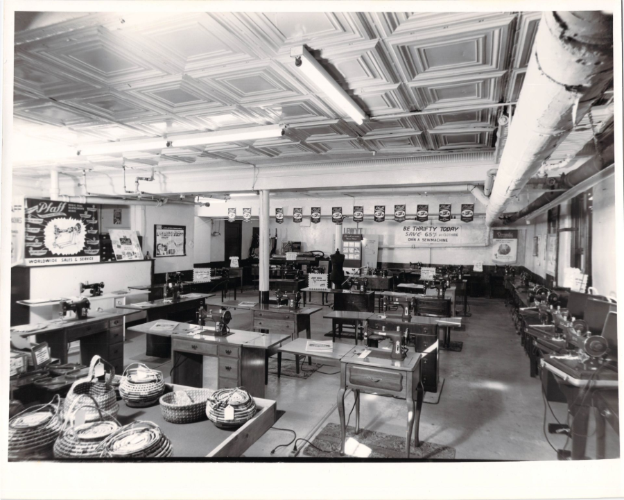 Black-and-white empty cafeteria with tables, trays, wall photos, and fluorescent ceiling lights
