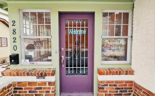 A purple door with a welcome sign on it