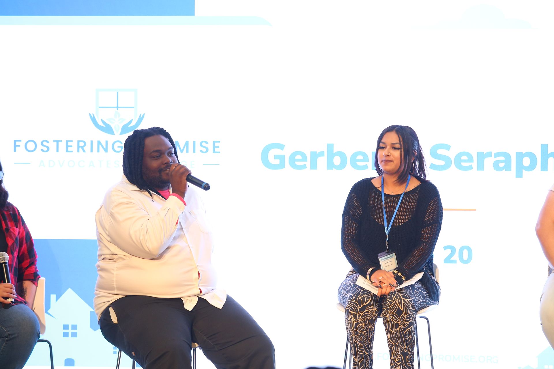 Panel discussion on stage with two speakers seated before a white “Gerber” backdrop