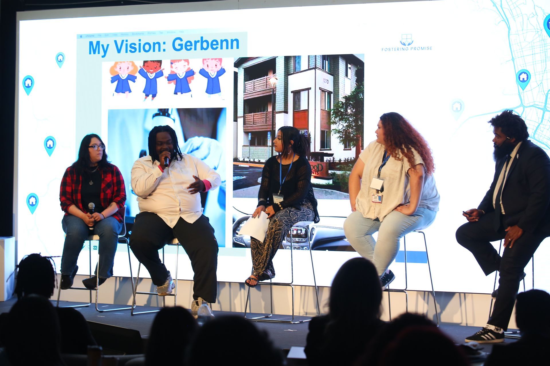 Panel discussion onstage with five speakers and a screen reading “My Vision: Gerbenn”