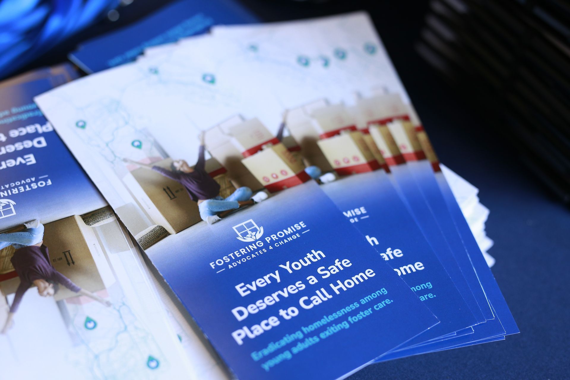 Blue pamphlets with a mosque illustration and text about a youth design call for peace.