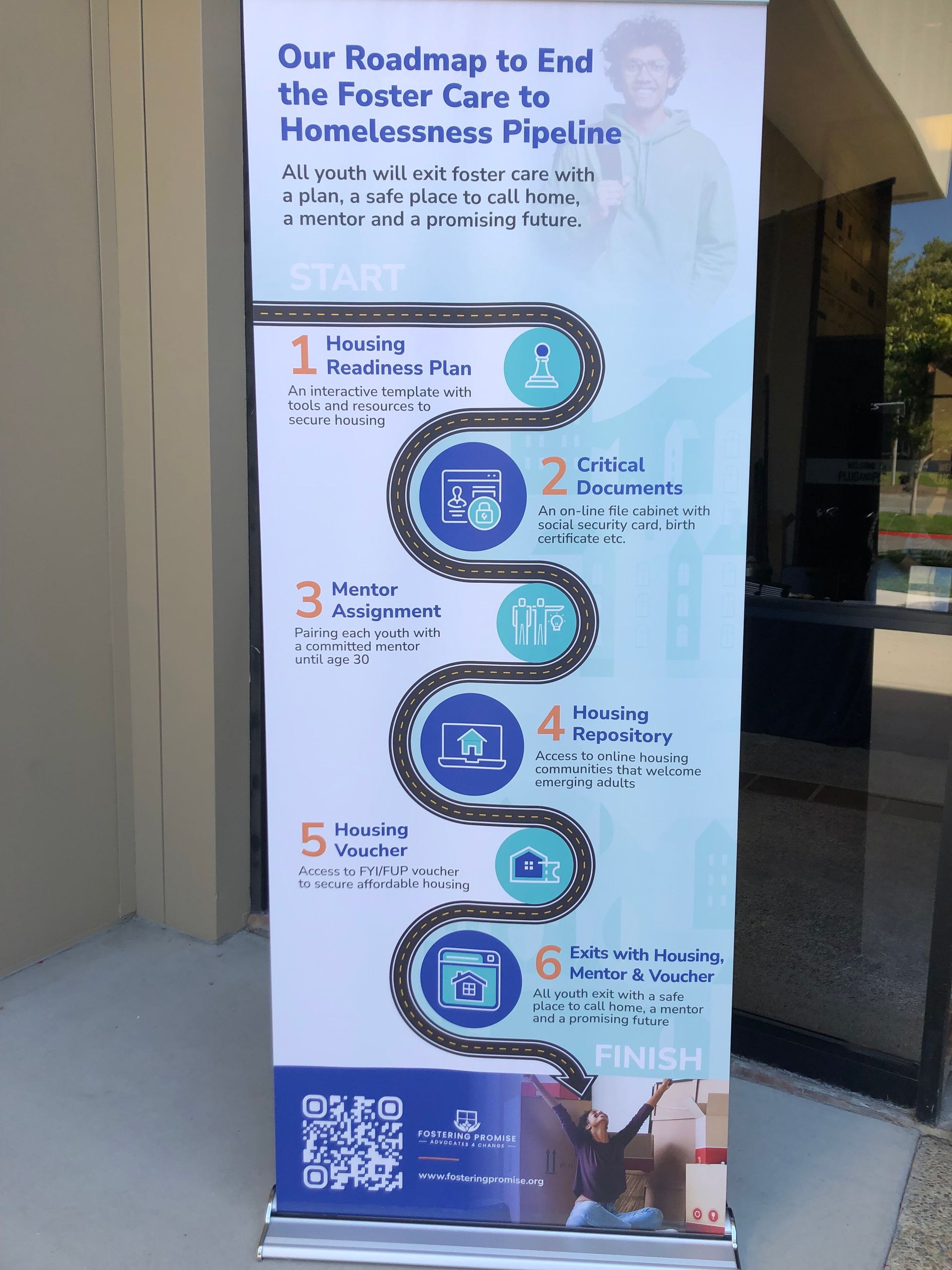Tall blue-and-white poster about ending the foster care-to-homelessness pipeline, with a QR code at the bottom.
