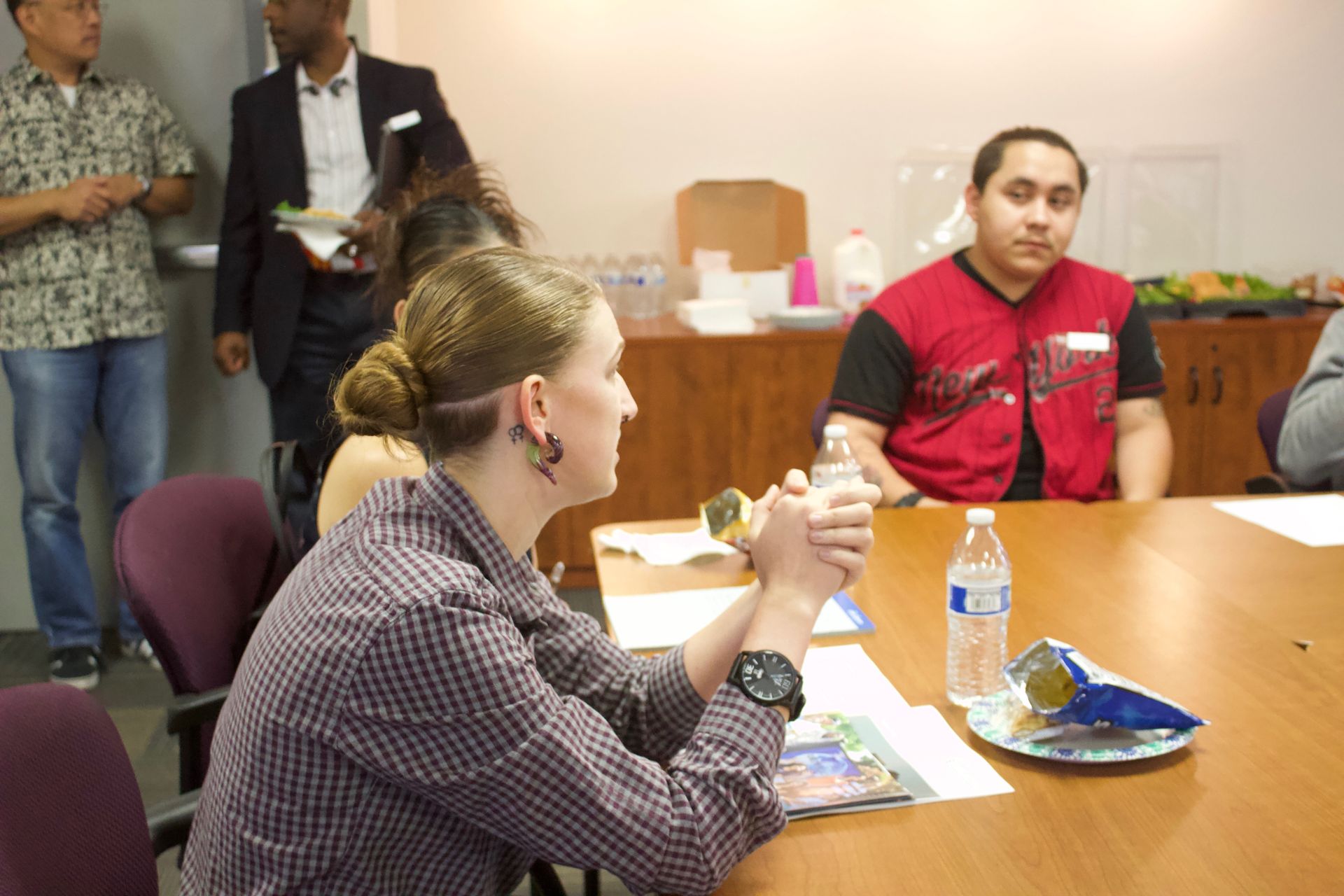 People seated around a meeting table with snacks and drinks in a conference room