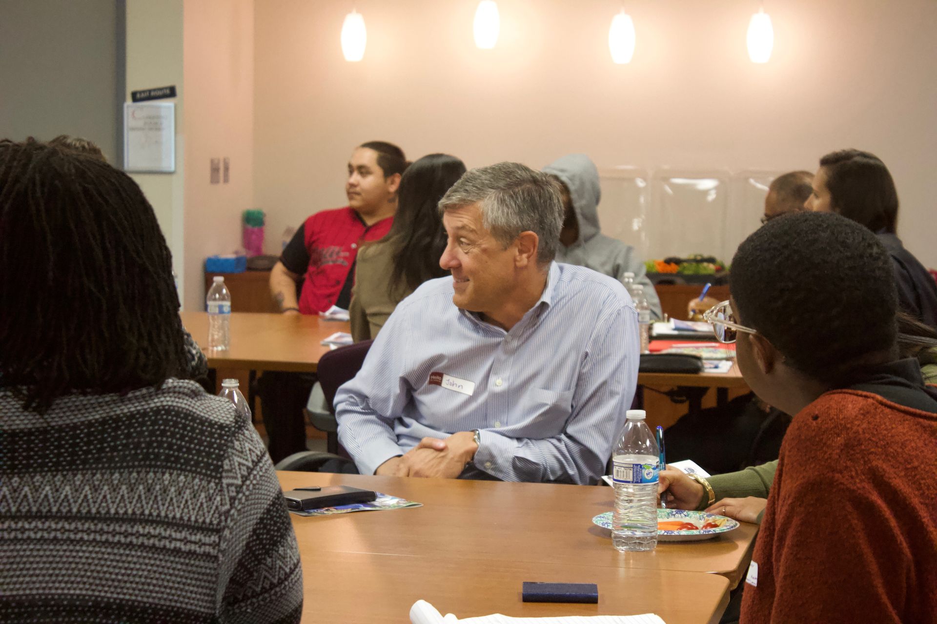People seated around a conference table in a meeting room, listening and discussing.