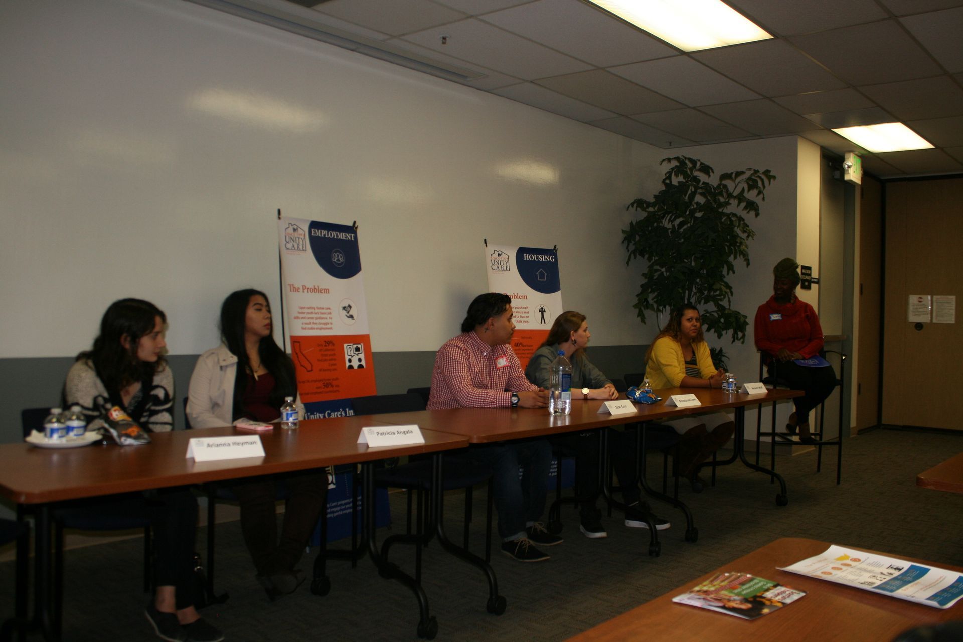 Panel discussion with six people seated at a long table in a conference room.