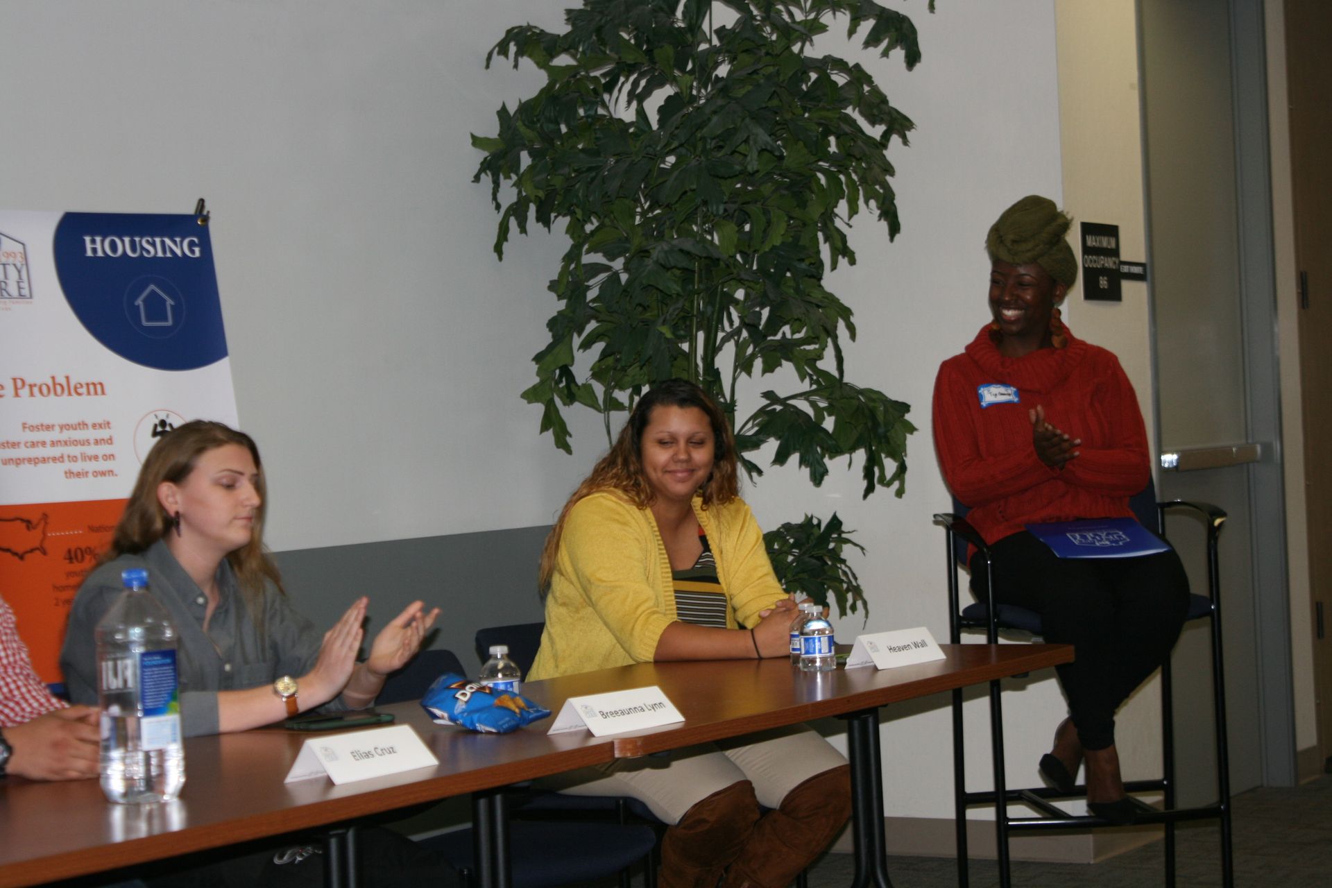 Panel discussion with three speakers seated at a table in a meeting room