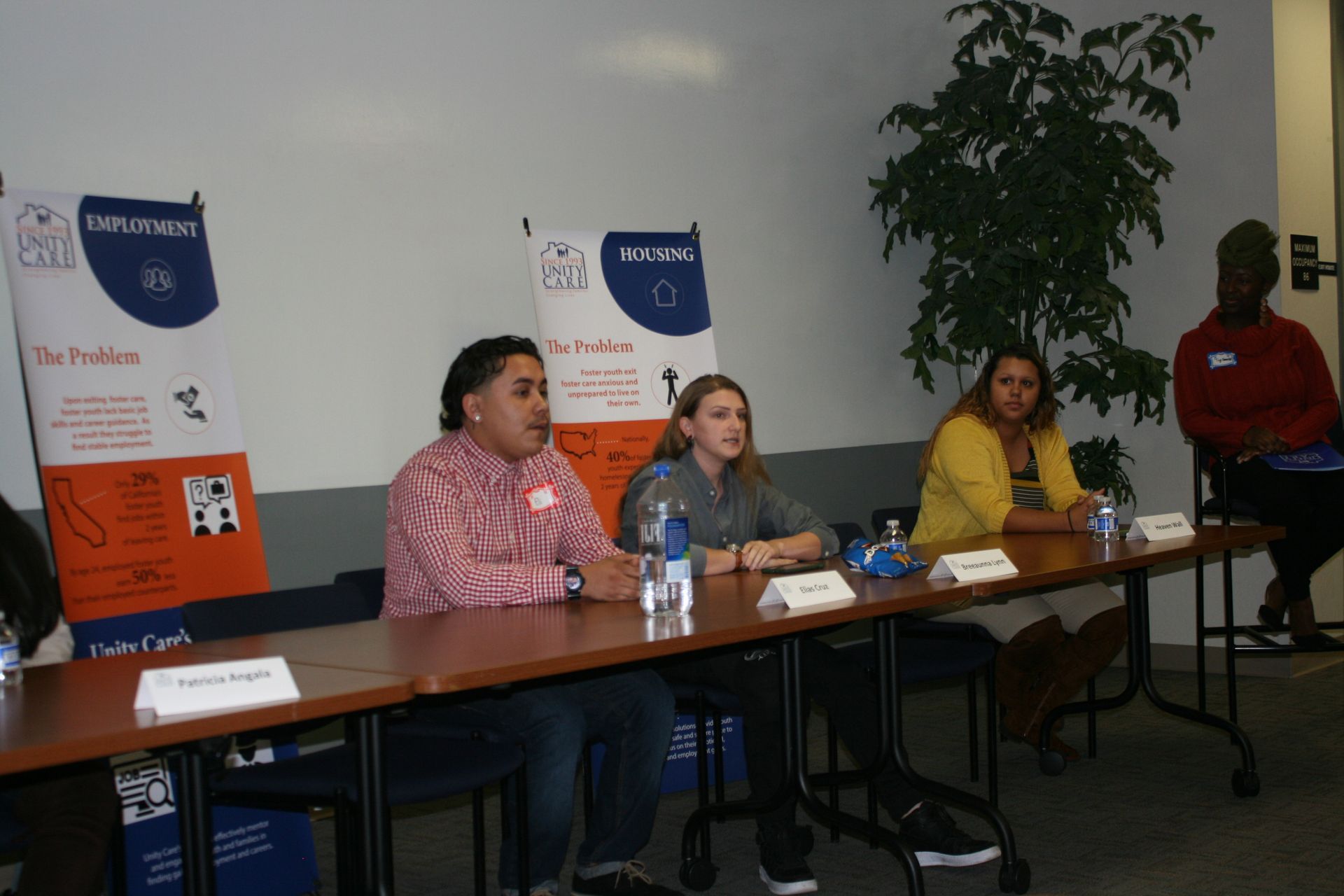 Panel discussion at a table with three speakers and microphones in a conference room