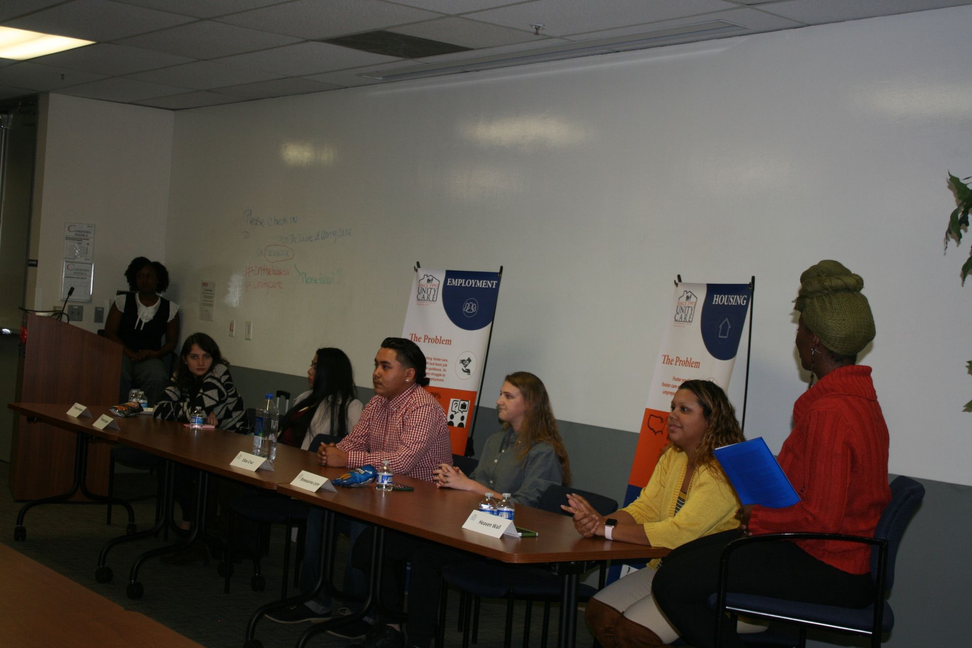 Panel discussion with several people seated at a long table in a classroom or conference room