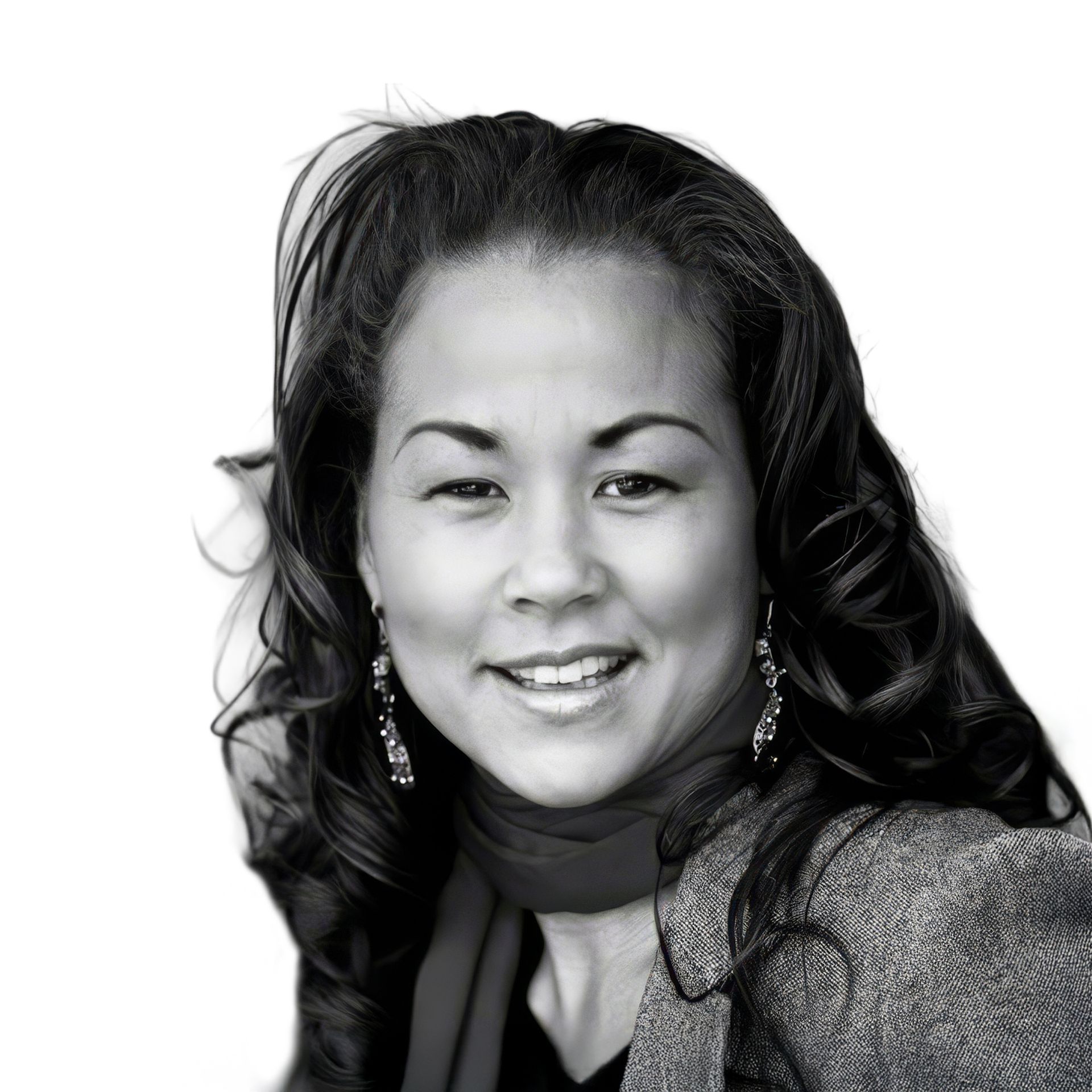 Smiling woman in a blazer and scarf, with long wavy hair, against a plain background