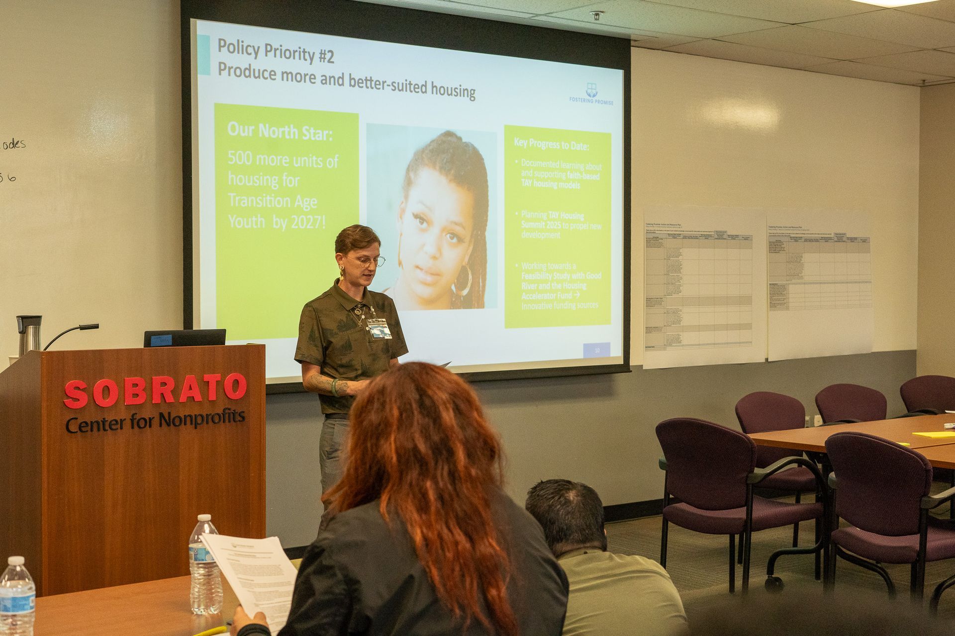 Presenter speaking in a classroom at Sobrato Center, with projected slide and seated audience.
