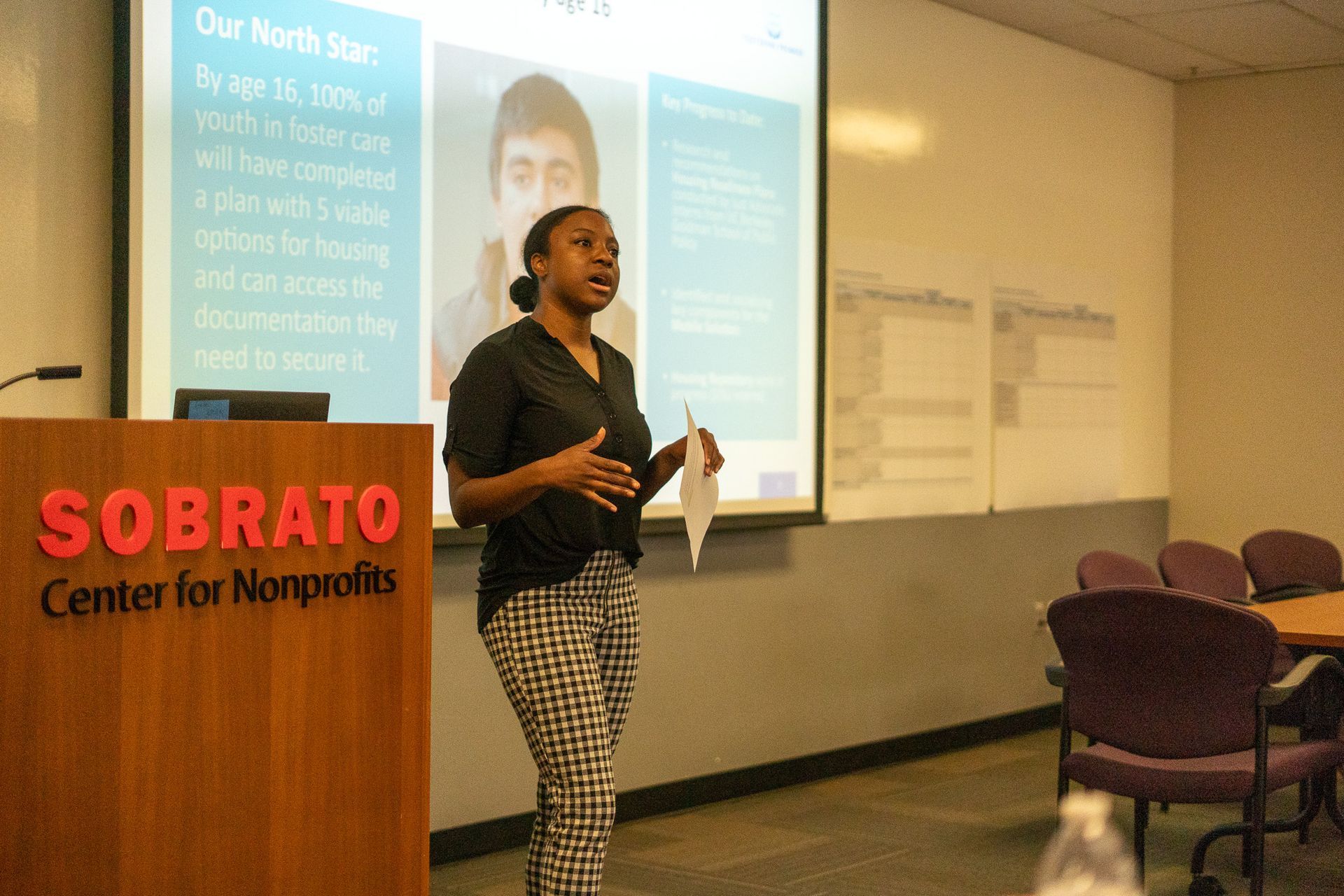 Presenter speaking beside a SOBRAO Center for Nonprofits podium in a conference room with projected slides