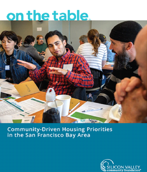 People discussing around a table at a community housing meeting, with “On the Table” title and Bay Area subtitle.