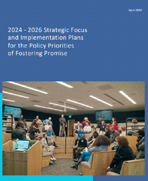 People seated in a meeting room, with a slide on the screen about 2024–2025 strategic focus and implementation plans.