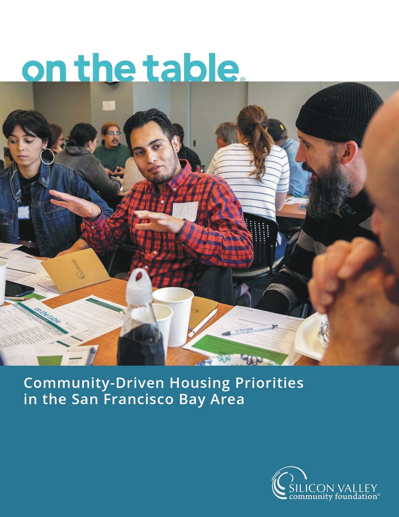 People discussing at a table in a meeting; cover reads “Community Driven Housing Priorities in the San Francisco Bay Area.”