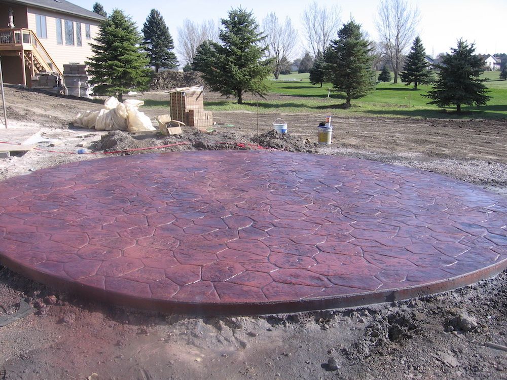 A circular concrete patio with a house in the background