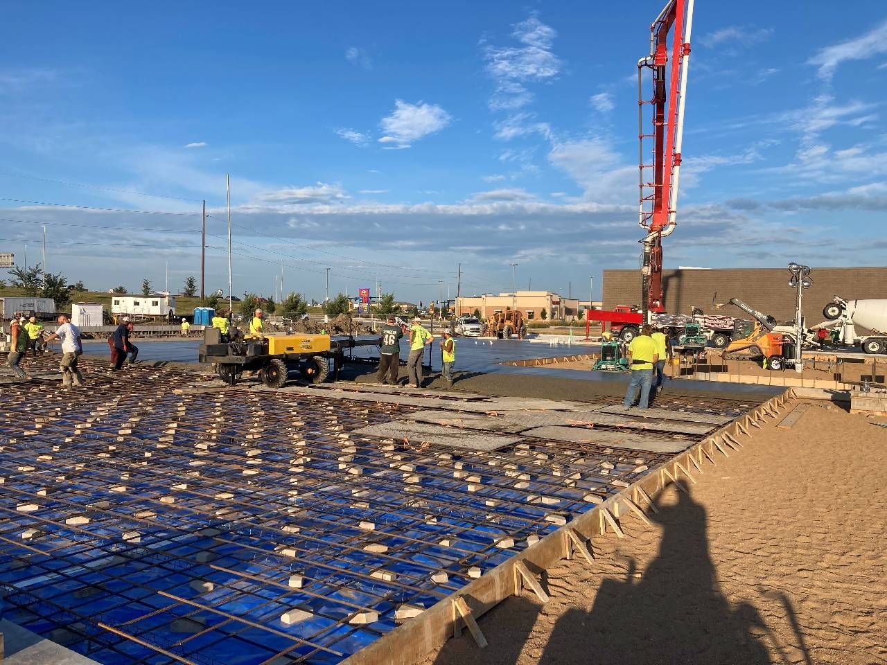 A group of construction workers are working on a concrete floor.
