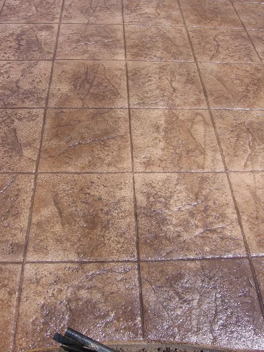 A close up of a tiled floor with a brush on it.
