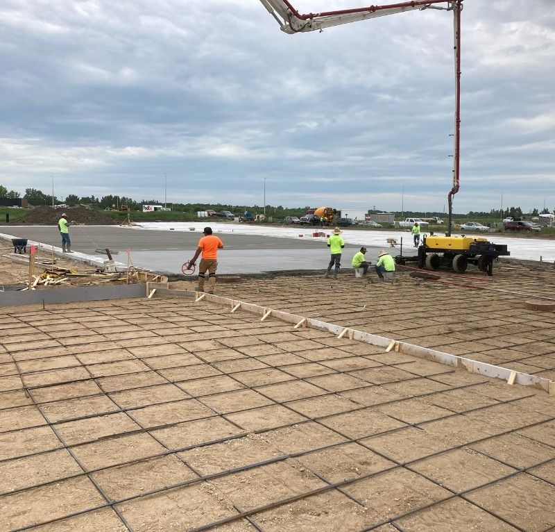 A group of construction workers are working on a concrete floor