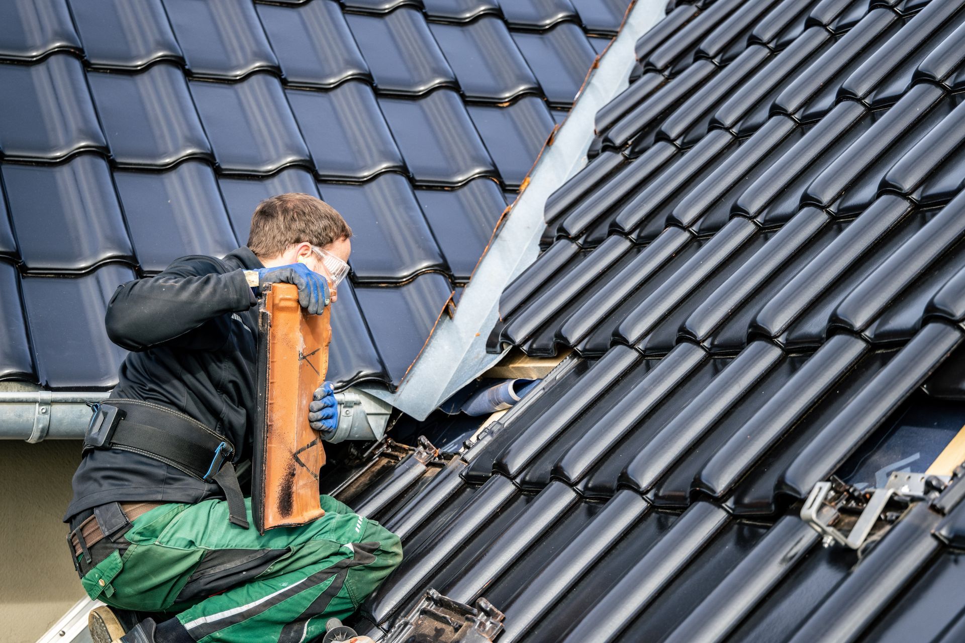 A man is working on the roof of a house.