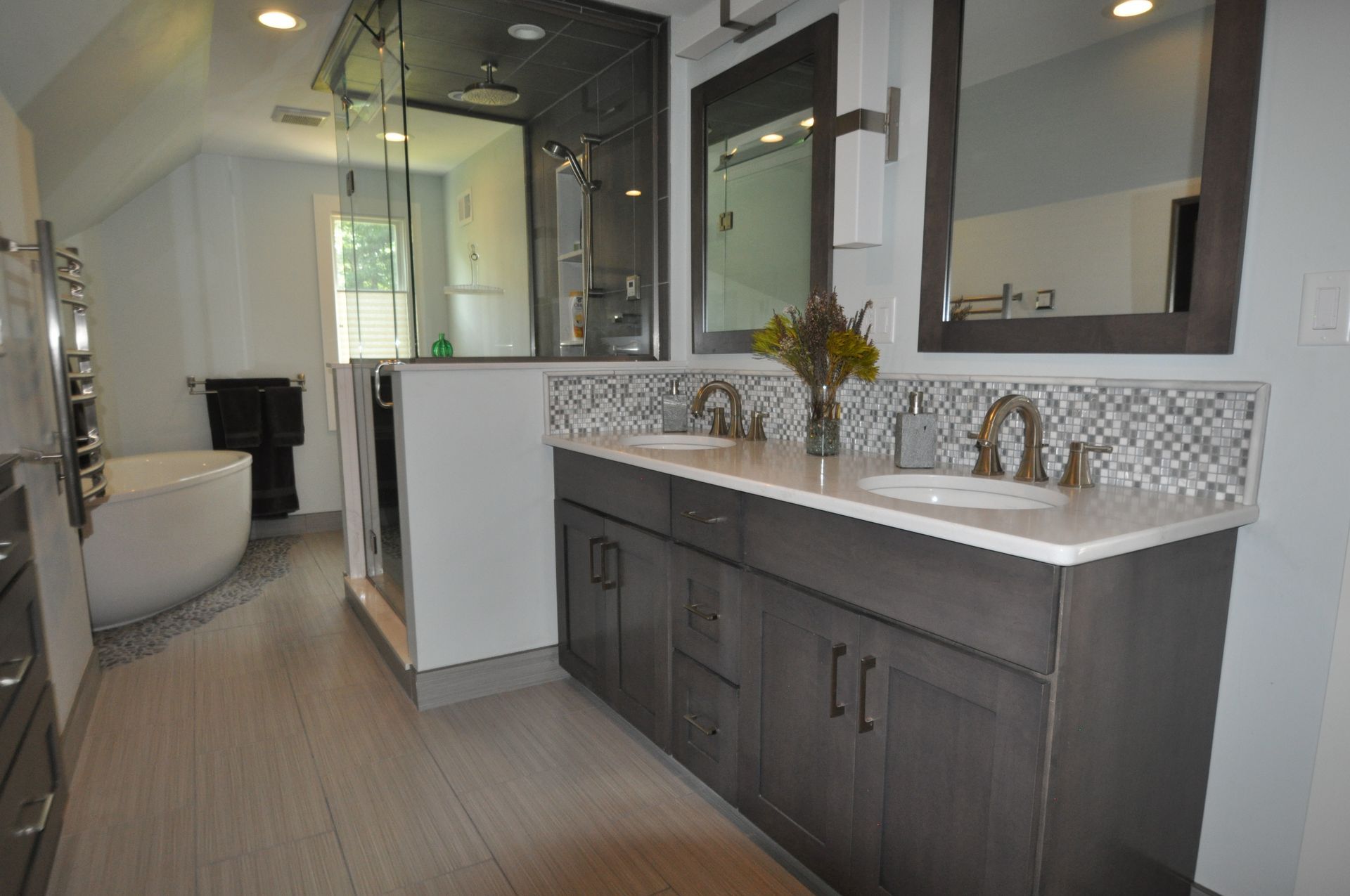 Modern bathroom with double vanity, walk-in shower, and freestanding tub; gray and white color scheme.