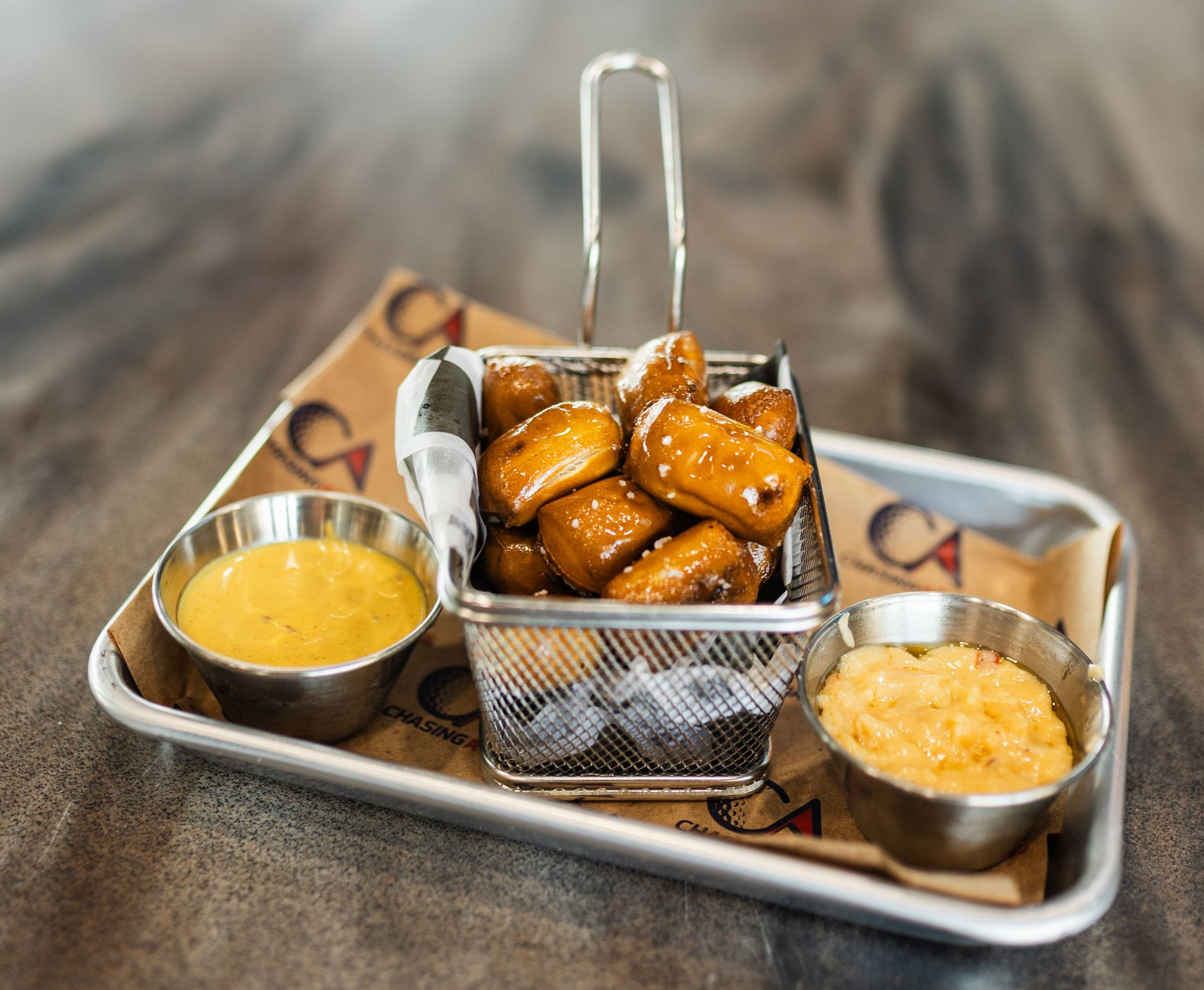 Tray of pretzels with two bowls of cheese on a restaurant table